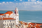 Stunning landscape of the Tejo estuary and Santo Estevao Church in Lisbon, Portugal, under a bright blue sky. The combination of water and architecture creates a tranquil and picturesque scene.