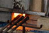 Blowpipes and a furnace in a glass-blowing studio in Venice, Italy.