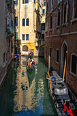 Eine Gondel mit Touristen in einem Kanal in Venedig,Italien.