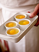 Four ramequins with eggs for poaching