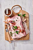 Pork belly with herbs and spices on a wooden board