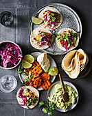 Tacos with grilled sweet potatoes, guacamole, red cabbage and queso fresco