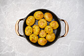 Baked baby potatoes with herbs in a roasting tin