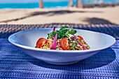 Quinoa salad with cherry tomatoes, coriander and red onions
