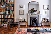 Classic living room with marble fireplace and wall of books, patterned carpet