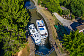 Aerial view of Écluse de de l'aiguille Puichéric look. Canal du Midi at village of Puichéric Carcassonne Aude South of France southern waterway waterways holidaymakers queue for a boat trip on the river, France, Europe