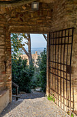 A gate into the Parco della Rocca, the ruins of a medieval fort in the walled town of San Gimignano, Italy.