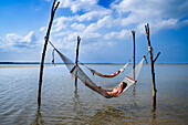 Twilight with couple in sea swing in the The residence luxury resort, Bintan island, Riau islands, Indonesia