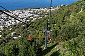 Touristen auf dem Monte Solaro Sessellift von Anacapri zum Monte Solaro Aussichtspunkt auf der Insel Capri, Italien. Die Stadt Anacapri ist unterhalb zu sehen.