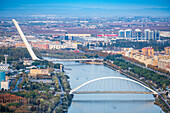 Enjoy a stunning aerial view of Barqueta and Alamillo bridges with Teatro Central nestled along the river in Seville.