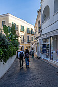 Tourists & shops on a street in the town of Capri, largest community on the island of Capri, Italy.