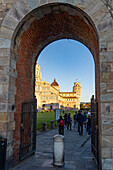 The Leaning Tower & Duomo of Pisa viewed through the gate through the city wall in Pisa, Italy.