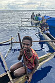 Residents of New Hanover island in their traditional dugout canoes, New Ireland province, Papua New Guinea