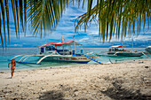 Traditional boats moored off a tiny tropical island beach in the Philippines Kalanggaman island, Malapascua, Cebu, Philippines