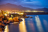 Beautiful coastal night scene in Andalusia, Spain, with illuminated cliffs and Mediterranean Sea.