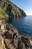 A walkway on the rocks along the water of the Lingurian Sea by Riomaggiore, Cinque Terre, Italy.