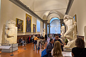 Unvollendete Werke von Michelangelo mit dem David im Hintergrund in der Accademia-Galerie in Florenz, Italien.