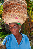 Woman seller of crafts, hats in the restaurant in front of the beach of plage de Ti Mouillage beach in Cayes-de-Jacmel, Cayes de Jacmel, Jacmel, Haiti.