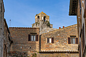 The top of the Torre Rognosa above buildings on Via San Giovanni in the medieval city of San Gemignano, Italy.