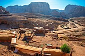 Tourist souvenir stall in front of the Urn tomb, Petra, Jordan. Shops selling souvenirs line the main path in from Petra, Jordan, while some locals with mules carry goods out.