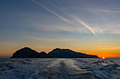 Colorful sky over the island of Capri at sunset in the Bay of Naples, Italy.