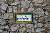 Ceramic street sign on the wall of the Casa Rossa in Anacapri on the island of Capri, Italy. Beside it is a Roman column.