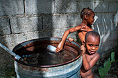 Children playing and bathing in precarious conditions in the plage de Ti Mouillage beach in Cayes-de-Jacmel, Cayes de Jacmel, Jacmel, Haiti.