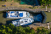 Aerial view of Écluse de de l'aiguille Puichéric look. Canal du Midi at village of Puichéric Carcassonne Aude South of France southern waterway waterways holidaymakers queue for a boat trip on the river, France, Europe