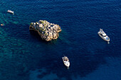 Pleasure boats in the clear waters of the Tyrrhenian Sea off the coast of the island of Capri, Italy.