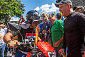 Motorcyclists affiliated with the government of Nicolas Maduro, from the group called Tumaparo, pass by the opposition rally.