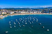 Aerial view of the Playa de la Concha beach and fishing boats and sport fishing boats to recreational boat fishing are moored in the harbor of Donostia San Sebastian.