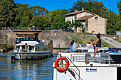 Boat crossing the Écluse de Marseillette look au Ranchin. Canal du Midi at village of Puichéric Carcassone Aude South of France southern waterway waterways holidaymakers queue for a boat trip on the river, France, Europe