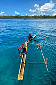 Residents of Tungelo Island in their traditional dugout canoes, New Ireland province, Papua New Guinea