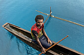 Residents of Tungelo Island in their traditional dugout canoes, New Ireland province, Papua New Guinea