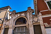 The ornately carved marble gate of a former residence on the Piazza Fabrizio de Andre in Carrara, Italy.