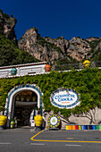 The entrance of a ceramic shop on the Amalfi Coast road in Italy. The rugged Lattari Mountains are behind.