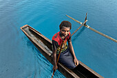 Residents of Tungelo Island in their traditional dugout canoes, New Ireland province, Papua New Guinea