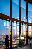 People enjoy breathtaking panoramic views of Seville from the observation deck of Torre Sevilla during sunset.