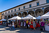 Open market vendors on the Piazza Santissima Annunziata in front of the Hospital of the Innocents in Florence, Italy.