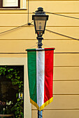 Ein Banner mit der italienischen Flagge an einer Straßenlaterne im historischen Zentrum der Stadt Sorrent, Italien.