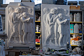 A cast resin model and finished bas relief marble sculpture in a marble carving studio in Carrara, Italy.