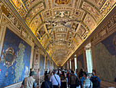 Tourists in the Gallery of Maps in the Vatican Museums, Vatican City, Rome, Italy.