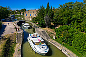 Aerial view of the triple écluse des moulins de Trèbes look aux portes du Minervois. Canal du Midi at village of Puichéric Carcassone Aude South of France southern waterway waterways holidaymakers queue for a boat trip on the river, France, Europe