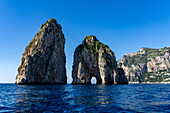 The Farallons or faraglioni, sea stacks off the coast of the island of Capri, Italy. L-R: Scopolo or Fuori & Mezzo with its sea arch.