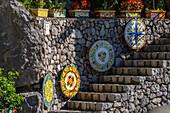 Large, colorful ceramic tabletops decorate a stone staircase at a ceramic shop on the Amalfi Coast of Italy.