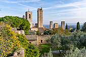 Der Parco della Rocca und mittelalterliche Türme in der ummauerten Stadt San Gimignano, Italien. L-R: Torre Rognosa, Campanile des Doms, Torre Grossa, Torre dei Becci, Torre Campatelli und Torre dei Cugnanesi.