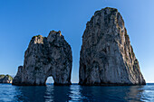 The Farallons or faraglioni, sea stacks off the coast of the island of Capri, Italy. L-R: Mezzo, with a boat visible through its sea arch, & Scopolo or Fuori.