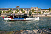 Passenger touristic cruise ship in the Seine river is moored to the pier near Louvre museum