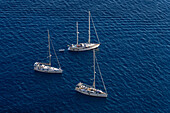 Sailboats in the waters of the Tyrrhenian Sea off the coast of the island of Capri, Italy.