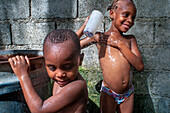 Children playing and bathing in precarious conditions in the plage de Ti Mouillage beach in Cayes-de-Jacmel, Cayes de Jacmel, Jacmel, Haiti.